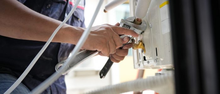 HVAC Maintenance and Repair Work, Professional Air Conditioner Installation or Service in Progress, Technician Repairing Outdoor Air Conditioning Unit with Wrench